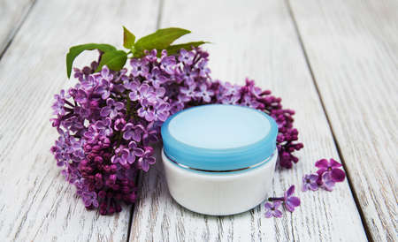 pot of moisturizing cream with lilac flowersの写真素材