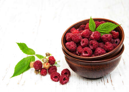 Bowl with raspberries on a old wooden backgroundの写真素材