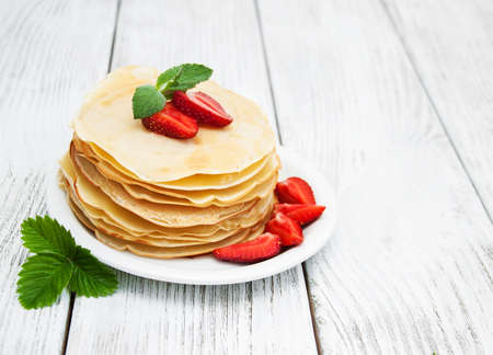 pancakes with strawberries  on a old wooden tableの写真素材