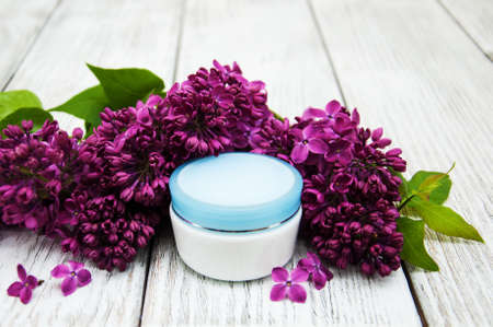 pot of moisturizing cream with lilac flowersの写真素材