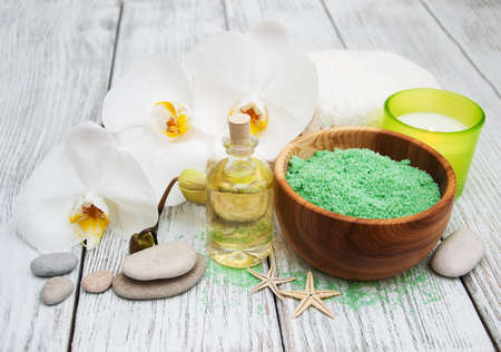Spa products and white orchids on a old wooden tableの写真素材
