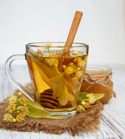 cup of herbal tea with linden flowers on a old wooden backgroundの写真素材