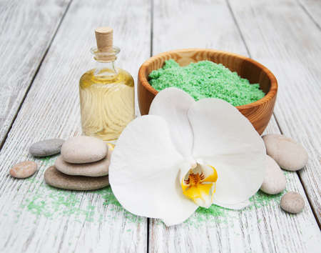 Spa products and white orchids on a old wooden tableの写真素材