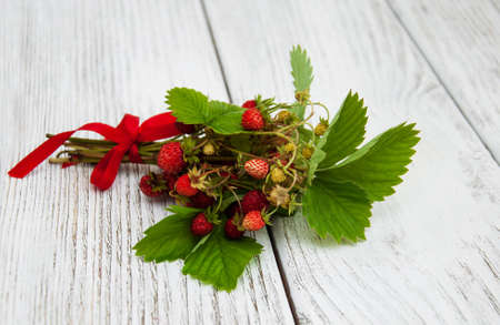bunch of wild strawberry on a wooden backgroundの写真素材
