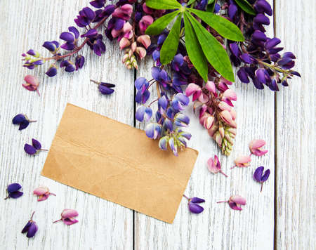 Lupine flowers with vintage card on a old wooden tableの写真素材