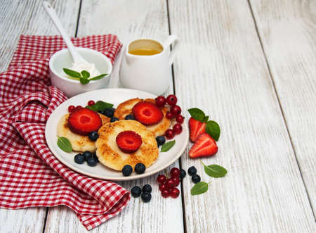 cottage cheese pancake with berries on a wooden tableの写真素材