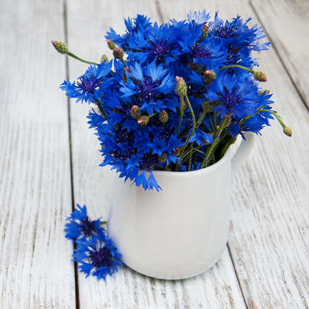 cornflowers in vase on a old wooden tableの写真素材