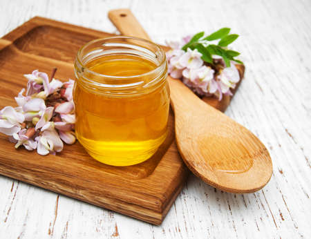 honey with acacia blossoms on a wooden backgroundの写真素材