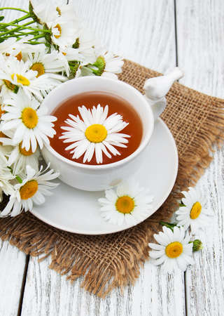 cup of herbal tea with chamomile flowers on a wooden tableの写真素材