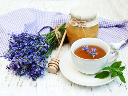 Cup of tea and lavender flowers on a old wooden backgroundの写真素材