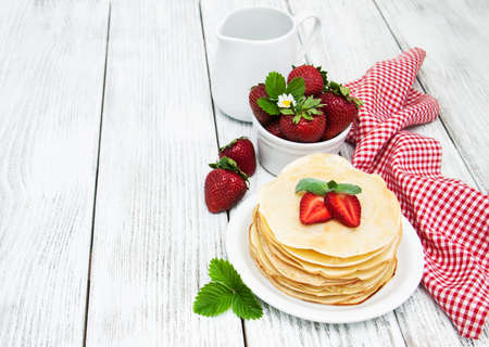 pancakes with strawberries on a old wooden tableの写真素材