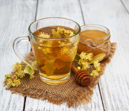 cup of herbal tea with linden flowers on a old wooden backgroundの写真素材
