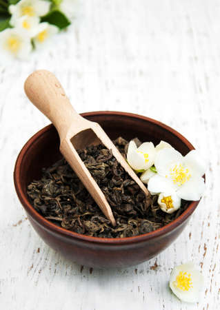 Dry green tea with jasmine flowers on a old wooden backgroundの写真素材