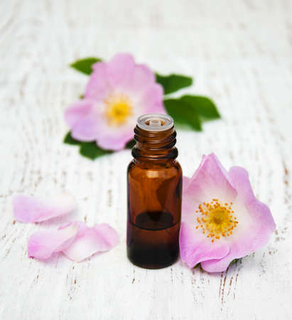 essential oil in glass bottles with dog rose flowersの写真素材