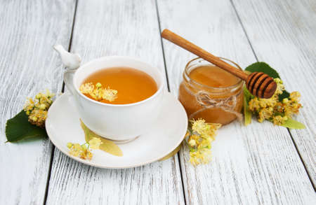 cup of herbal tea with linden flowers on a old wooden backgroundの写真素材