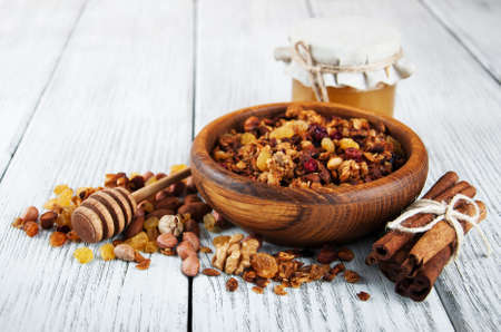 Homemade granola with nuts and honey on a wooden tableの写真素材