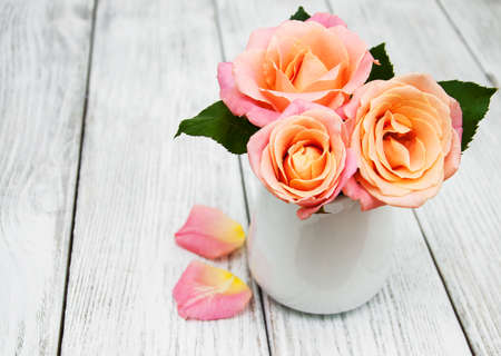 Vase with  Pink roses on a old white wooden backgroundの写真素材