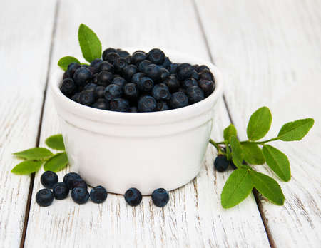 Bowl with Blueberries on a old wooden backgroundの写真素材