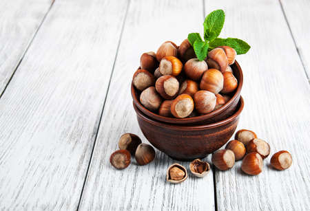 Bowl with hazelnuts on a old wooden tableの写真素材