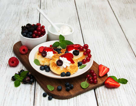 cottage cheese pancake with berries on a wooden tableの写真素材