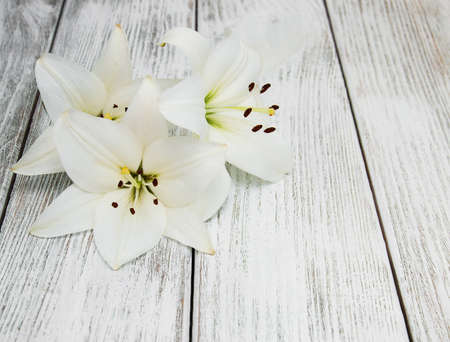 White  lilies on a old wooden backgroundの写真素材