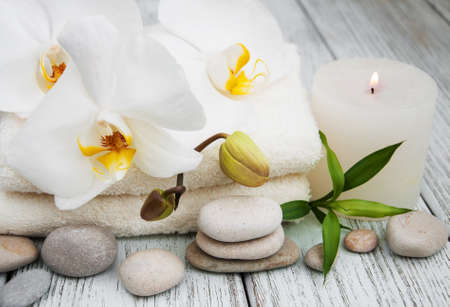 Spa products and white orchids on a old wooden tableの写真素材