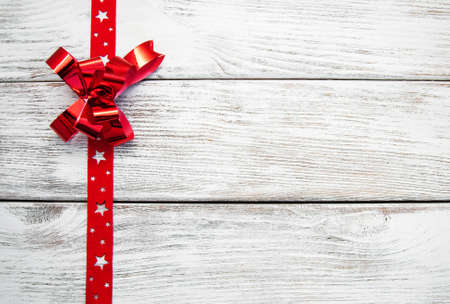 decorative red ribbon and bow over wooden backgroundの写真素材
