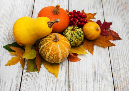 Pumpkin and autumn  leaves on a old wooden tableの写真素材