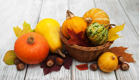Pumpkin and autumn  leaves on a old wooden tableの写真素材