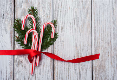 christmas candy cane with ribbon on a old wooden tableの写真素材