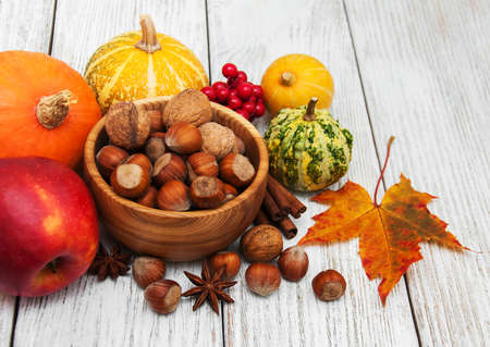 Hazelnuts and pumpkins on a old wooden tableの写真素材