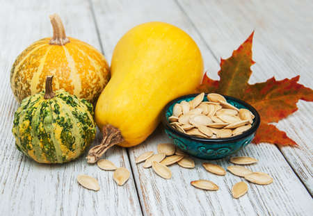 Pumpkins and seed on a old wooden tableの写真素材
