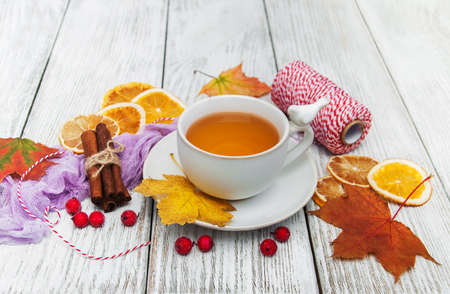 hot tea with spices in  cup and falling leavesの写真素材