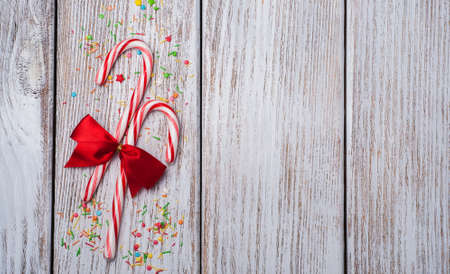 christmas candy cane with ribbon on a old wooden tableの写真素材