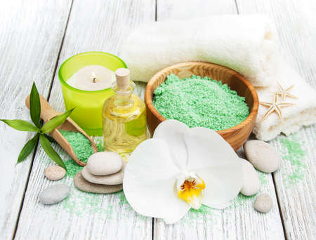 Spa products and white orchids on a old wooden tableの写真素材