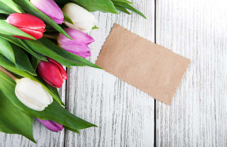 tulip bouquet and blank card on a wooden backgroundの写真素材