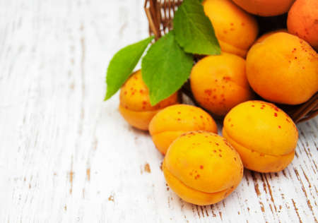 Basket with apricots on a old wooden backgroundの写真素材