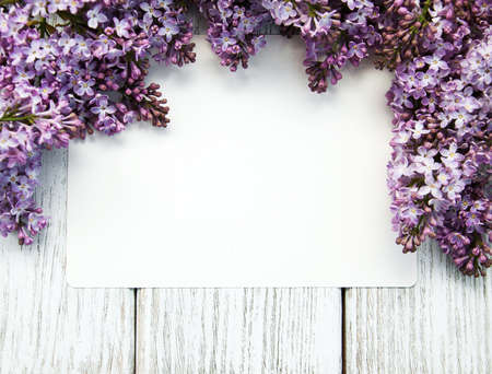 Lilac flowers with empty card on a old wooden backgroundの写真素材