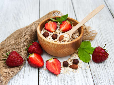 Muesli with strawberries on a old wooden tableの写真素材