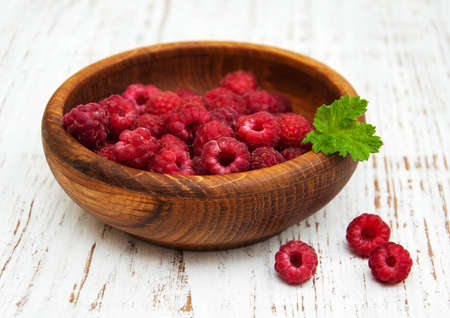 Bowl with raspberries on a old wooden backgroundの写真素材