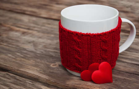 Cup and red hearts on a old wooden table