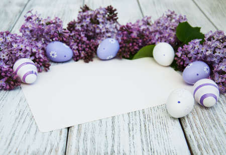 Easter card with easter eggs and lilac flowersの写真素材
