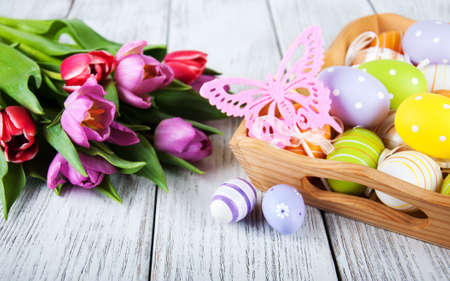 Easter eggs and tulips on a wooden table