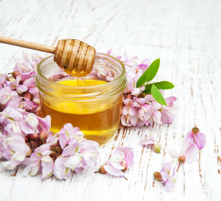 honey with acacia blossoms on a wooden backgroundの写真素材
