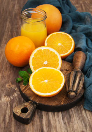 Jar of juice and fresh oranges  on a old wooden tableの写真素材