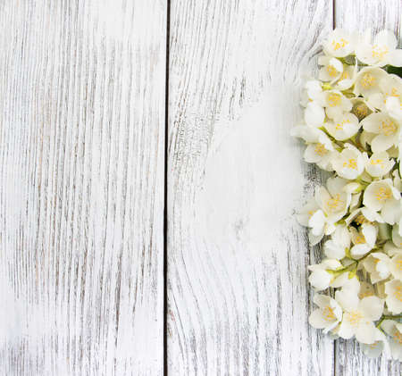 Border with jasmine flowers on a wooden backgroundの写真素材