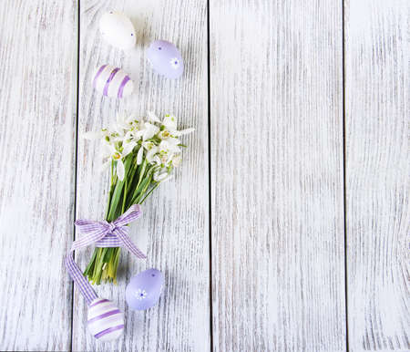 snowdrops and easter eggs on a old wooden table