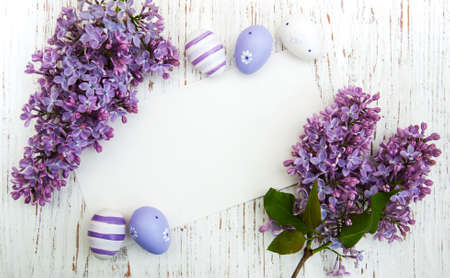 Easter card with easter eggs and lilac flowersの写真素材