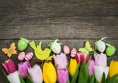 Easter eggs and tulips  on a old wooden backgroundの写真素材