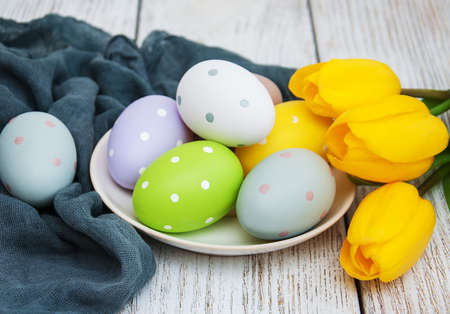 Easter eggs and tulips  on a old wooden background